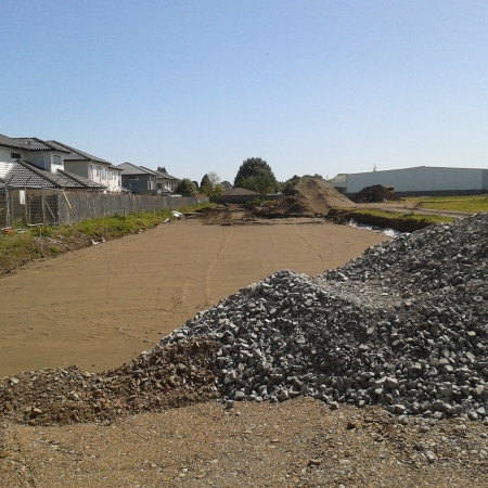 image of gravel pile in front of levelled dirt area for car park