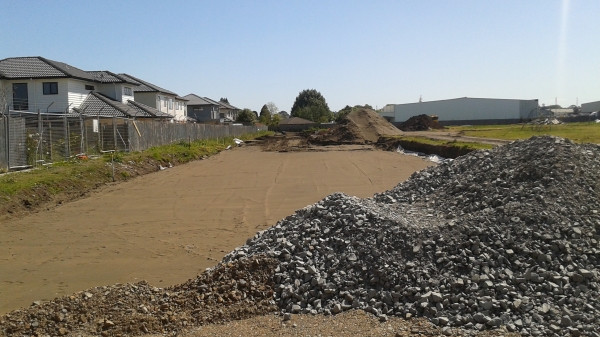 image of gravel pile in front of levelled dirt area for car park