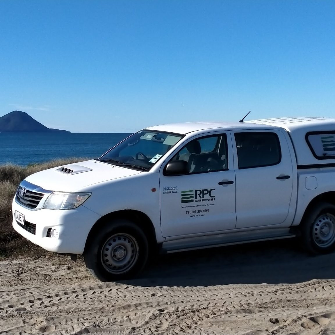 image of RPC Land Surveyors truck in front of ocean