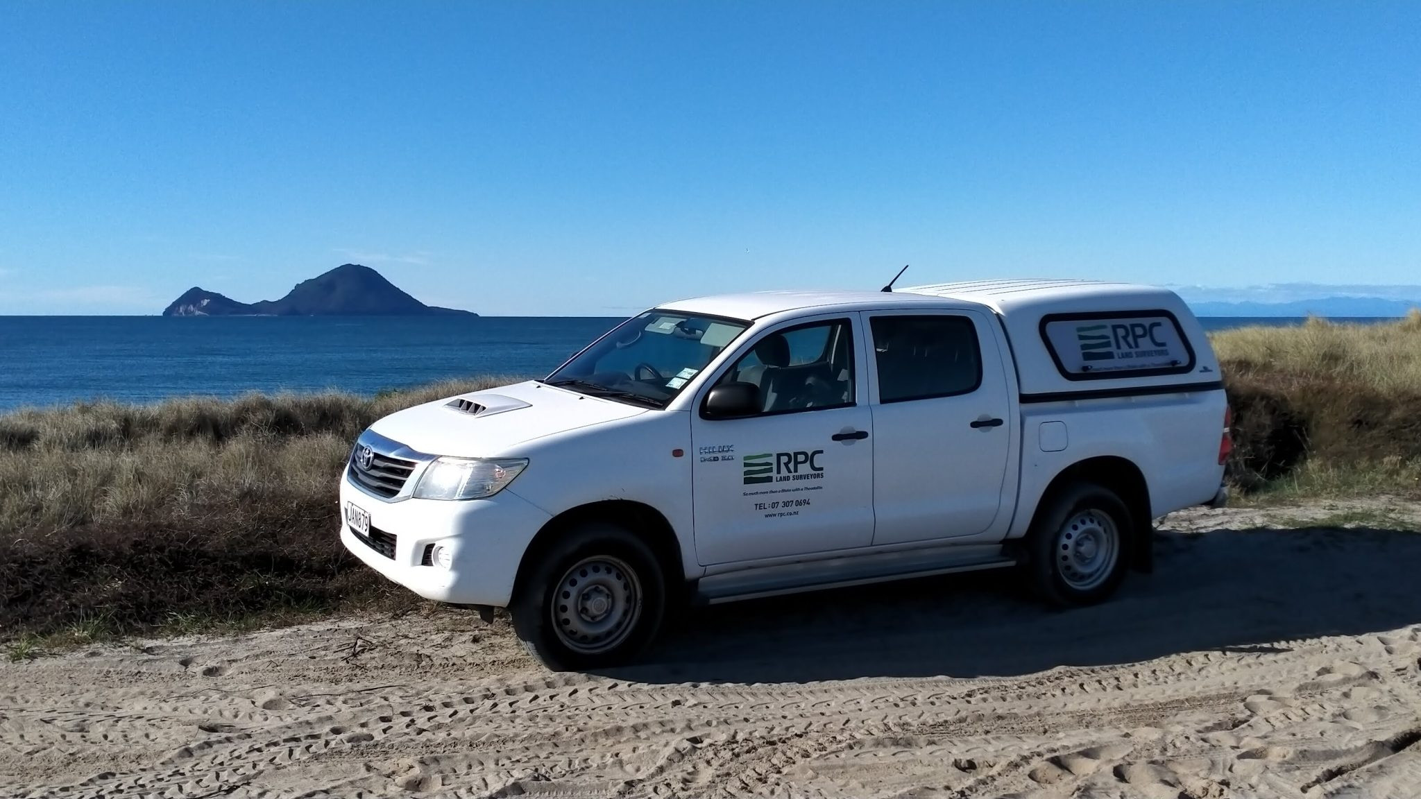 image of RPC Land Surveyors truck in front of ocean