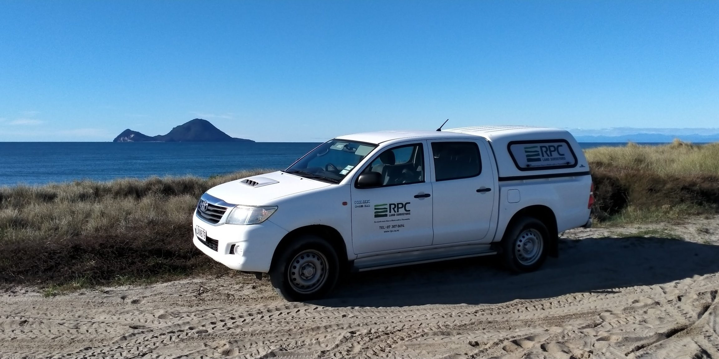image of RPC Land Surveyors truck in front of ocean