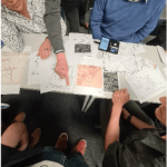 image of a group of people discussing surveying maps
