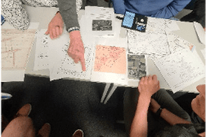 image of a group of people discussing surveying maps