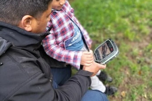 Image of father and child with surveying device