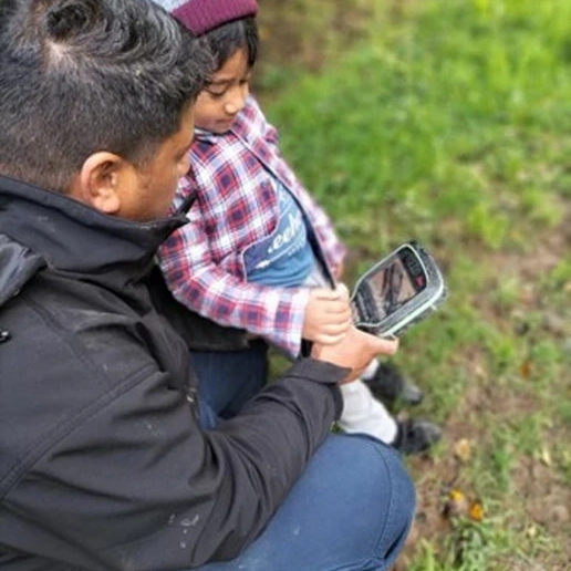 Image of father and child with surveying device